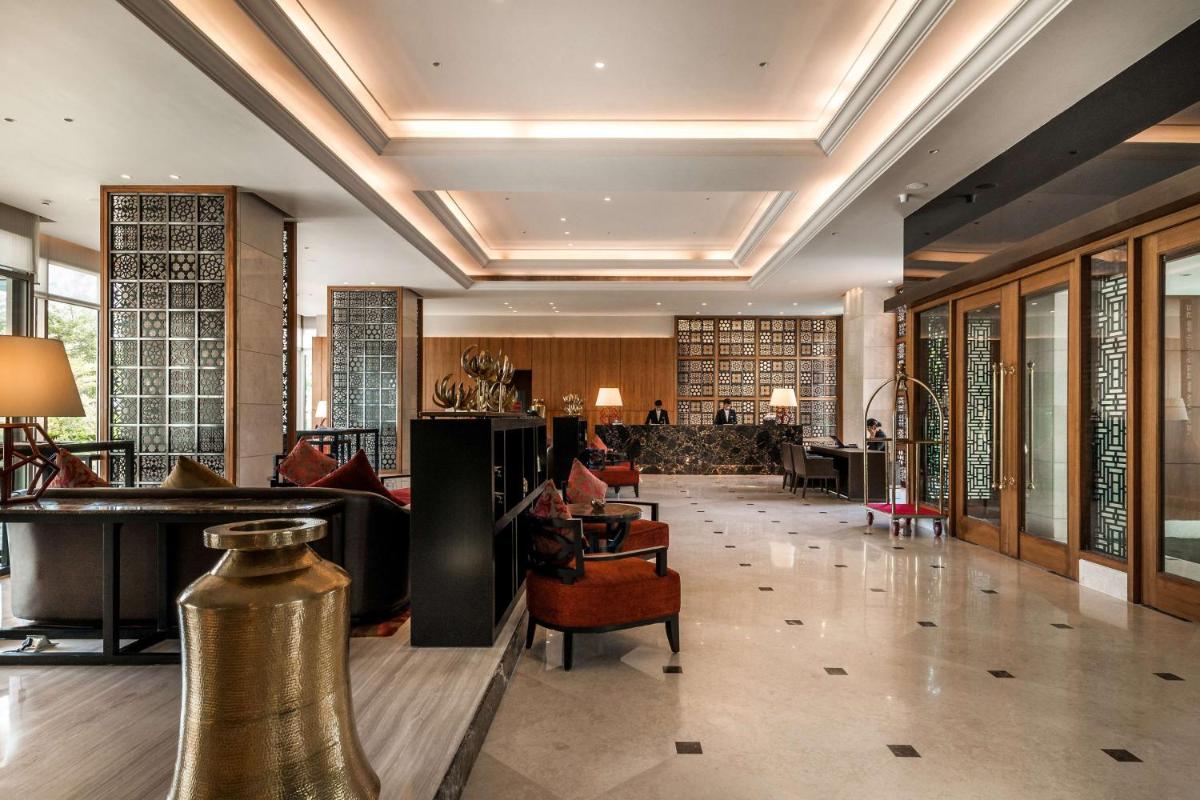 a lobby of a hotel with a table and chairs at Hyatt Ahmedabad in Ahmedabad