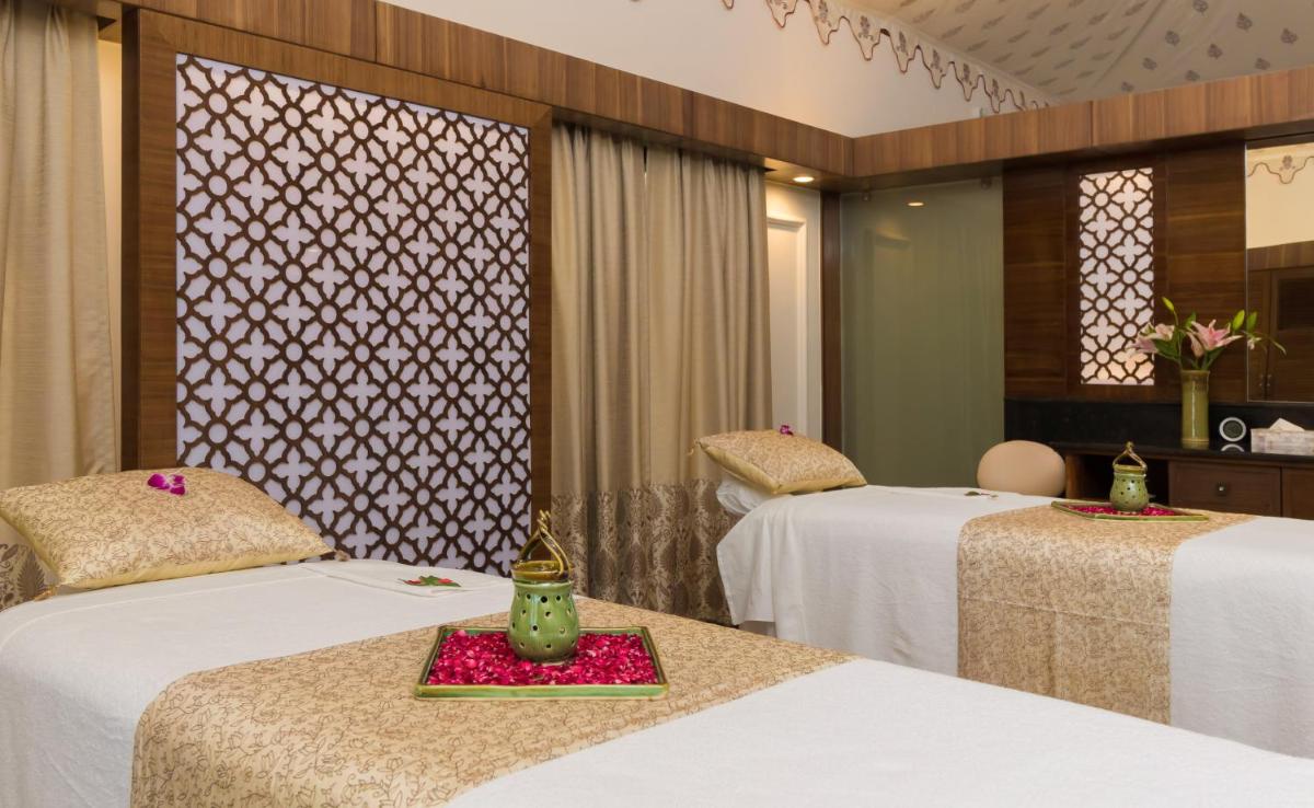 a hotel room with two beds with flowers on them at Jai Mahal Palace in Jaipur