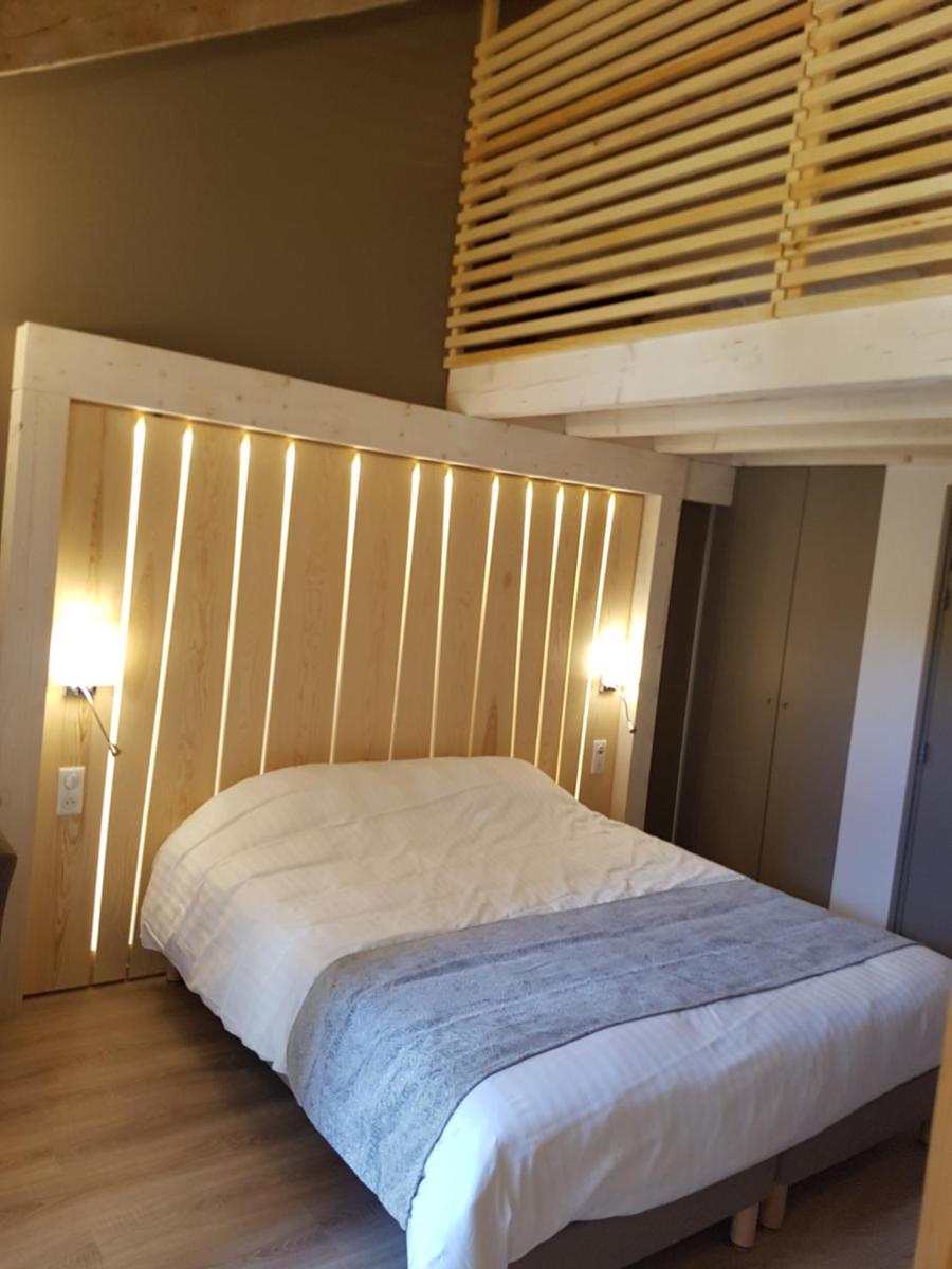 - une chambre avec un lit éclairé dans l'établissement Logis SPA Hotel Restaurant De La Poste, à Tence