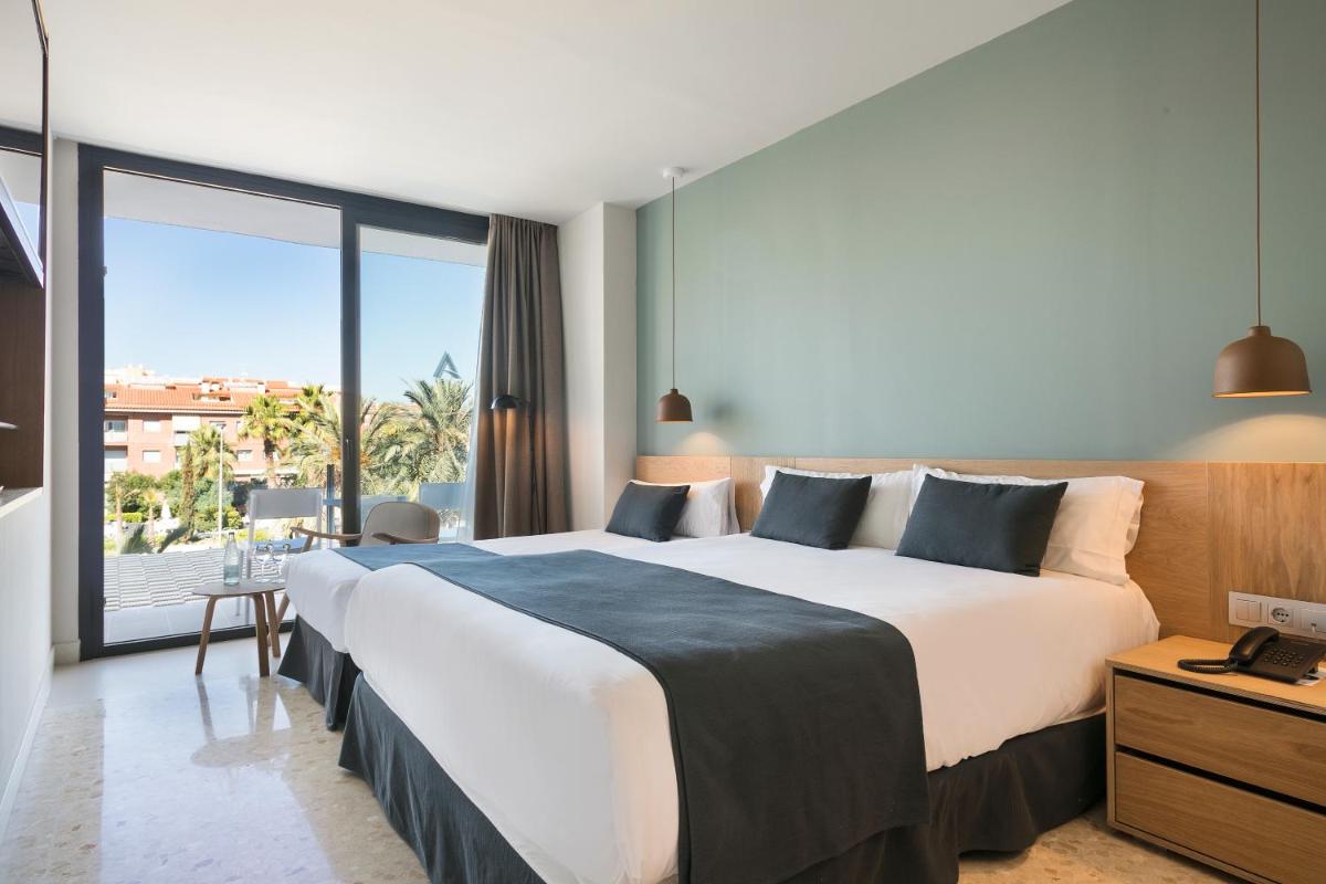 Un dormitorio con una cama grande y una ventana grande. en AQUA Hotel Silhouette & Spa - Adults Only, en Malgrat de Mar Un dormitorio con una cama grande y una ventana grande. en AQUA Hotel Silhouette & Spa - Adults Only, en Malgrat de Mar