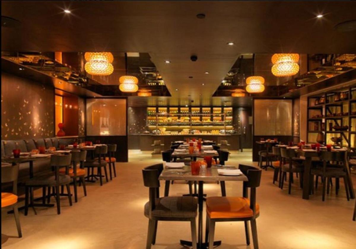 a restaurant with tables and chairs and a bar at The Park Bangalore, MG Road in Bengaluru a restaurant with tables and chairs and a bar at The Park Bangalore, MG Road in Bengaluru