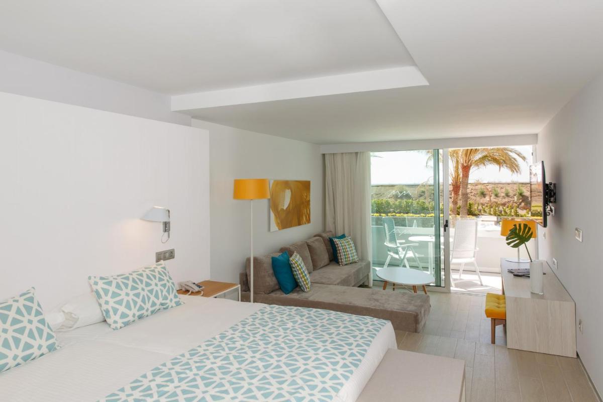 Un dormitorio blanco con una cama y una sala de estar. en Santa Monica Suites Hotel, en Playa del Inglés 81 fotos más