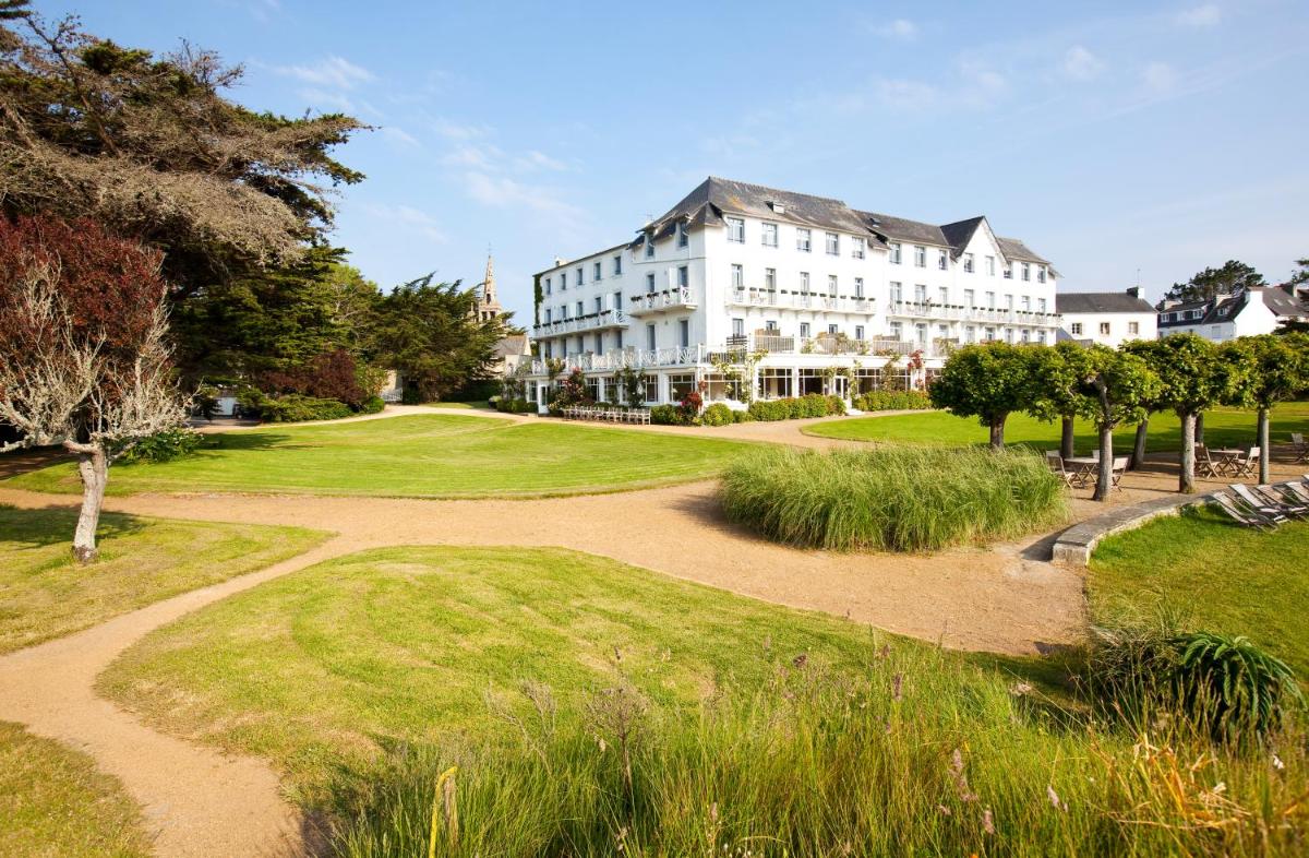 un grand bâtiment blanc au milieu d'un parc dans l'établissement Le Grand Hotel des Bains & Spa - Bretagne, à Locquirec