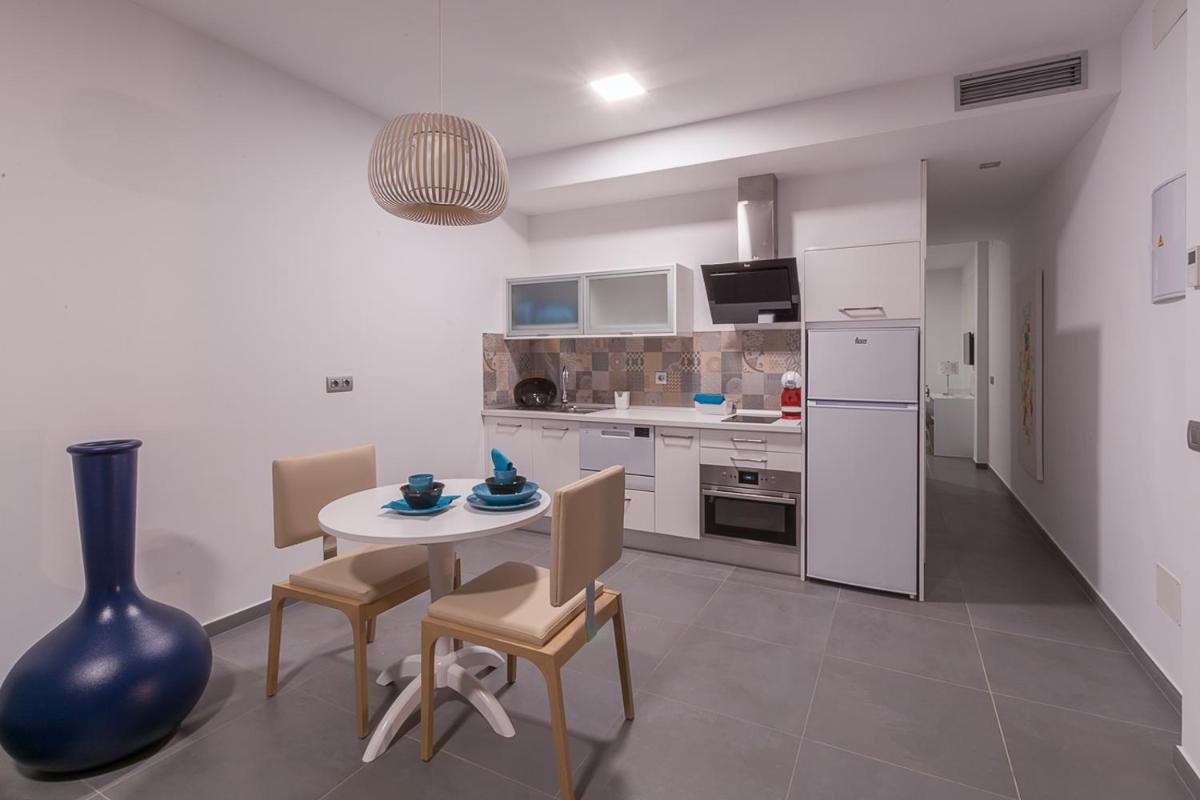 Una cocina con mesa y sillas y un refrigerador. en Silvi Villas by TAM Resorts, en Playa del Inglés