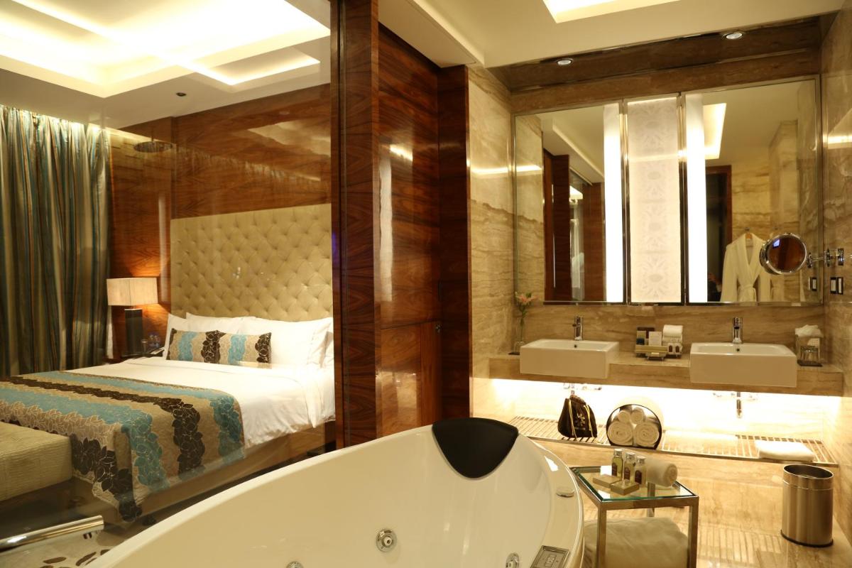 a bathroom with a bed and a bath tub at Taj City Centre Gurugram in Gurgaon