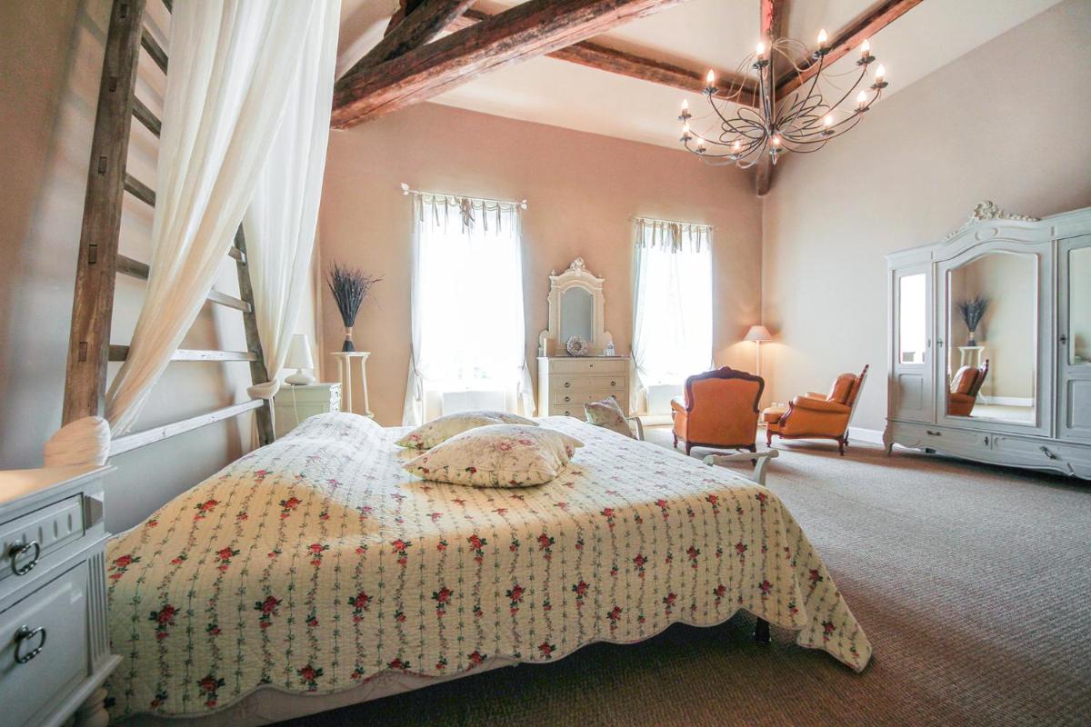une chambre avec un lit et un lustre dans l'établissement Les Carmes and spa, au Thor 72 autres photos