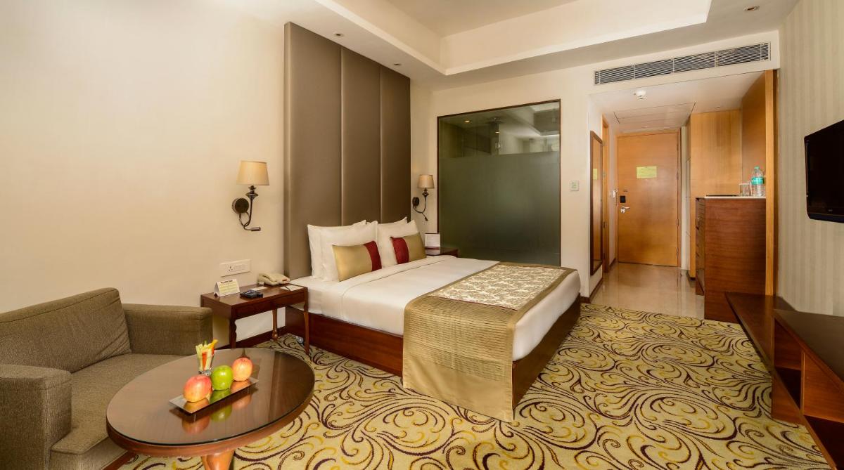 a hotel room with a bed and a couch at Pride Plaza Hotel, Kolkata in Kolkata