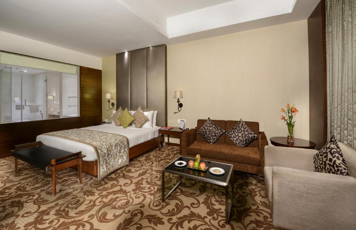 a hotel room with a bed and a couch at Pride Plaza Hotel, Kolkata in Kolkata