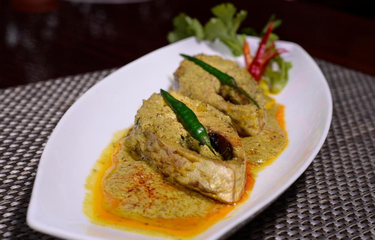 a white plate with some food on a table at Pride Plaza Hotel, Kolkata in Kolkata