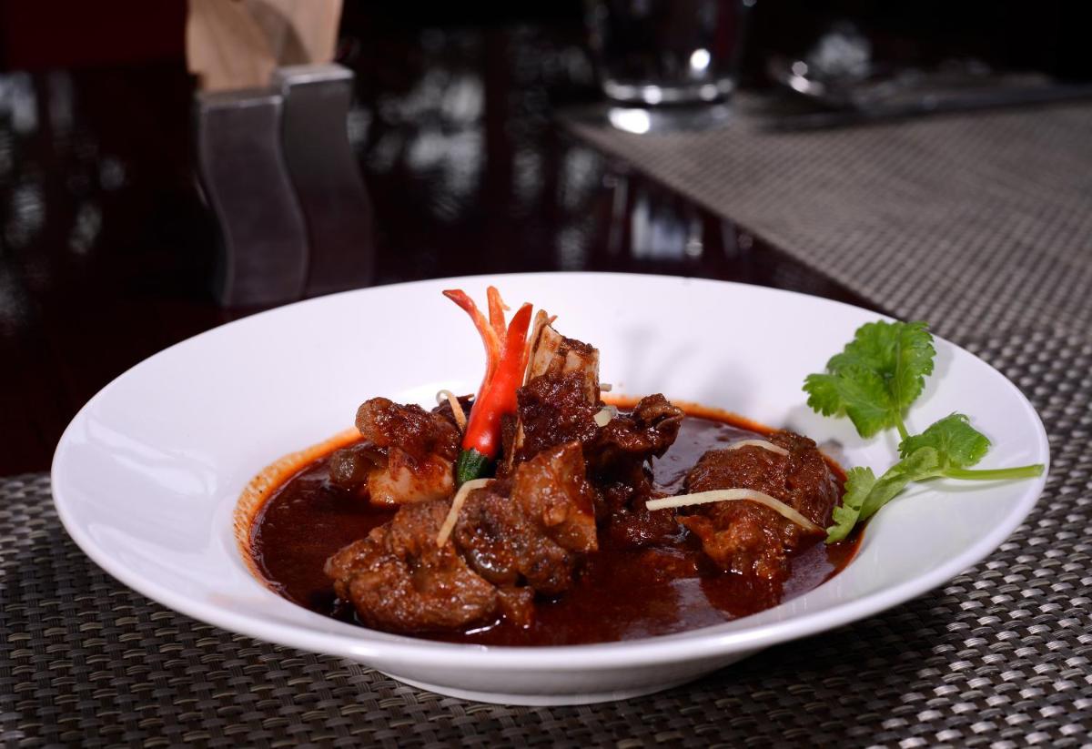 a white plate of food on a table at Pride Plaza Hotel, Kolkata in Kolkata