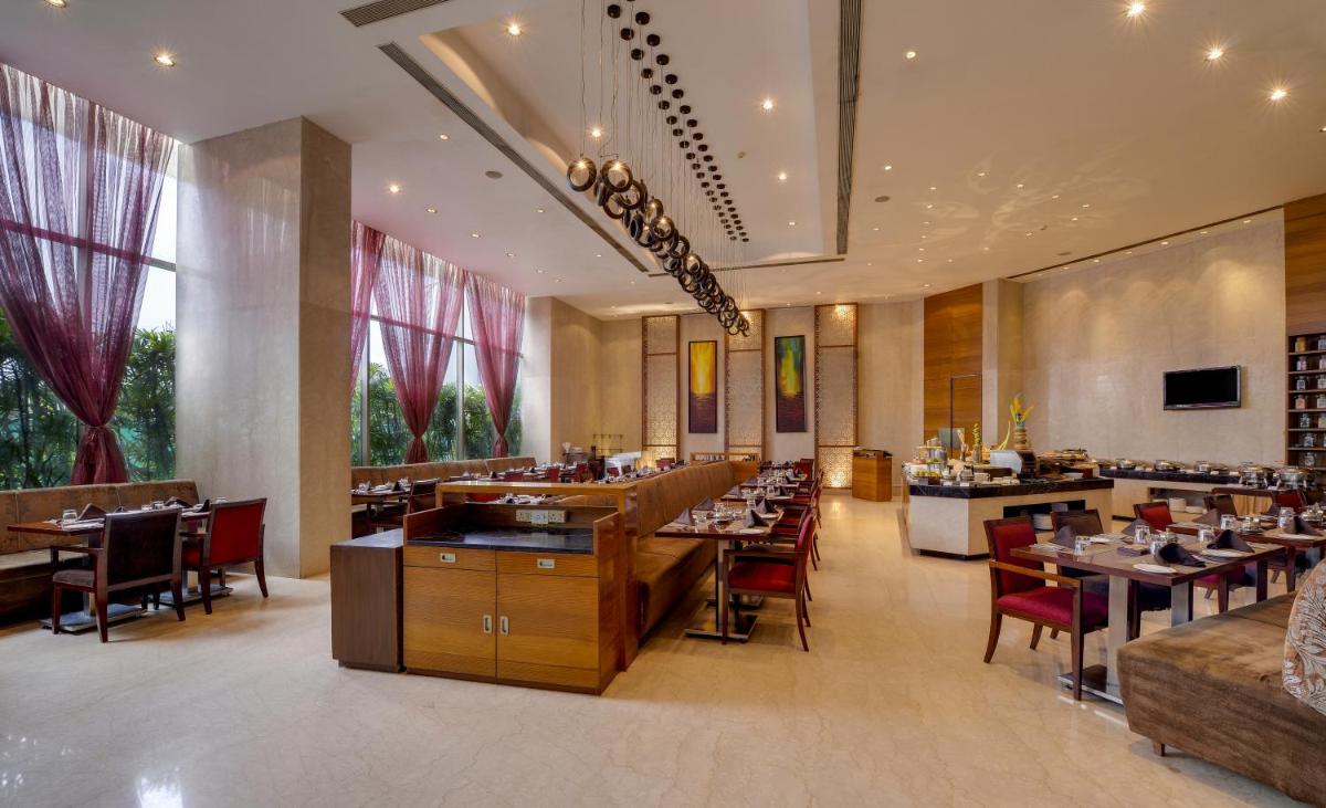 a dining room with tables and chairs in a restaurant at Pride Plaza Hotel, Kolkata in Kolkata