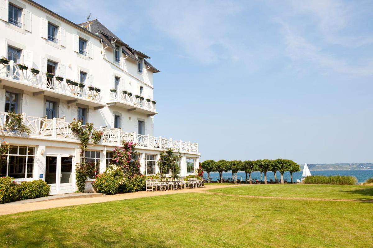 un hôtel avec une pelouse devant lui dans l'établissement Le Grand Hotel des Bains & Spa - Bretagne, à Locquirec