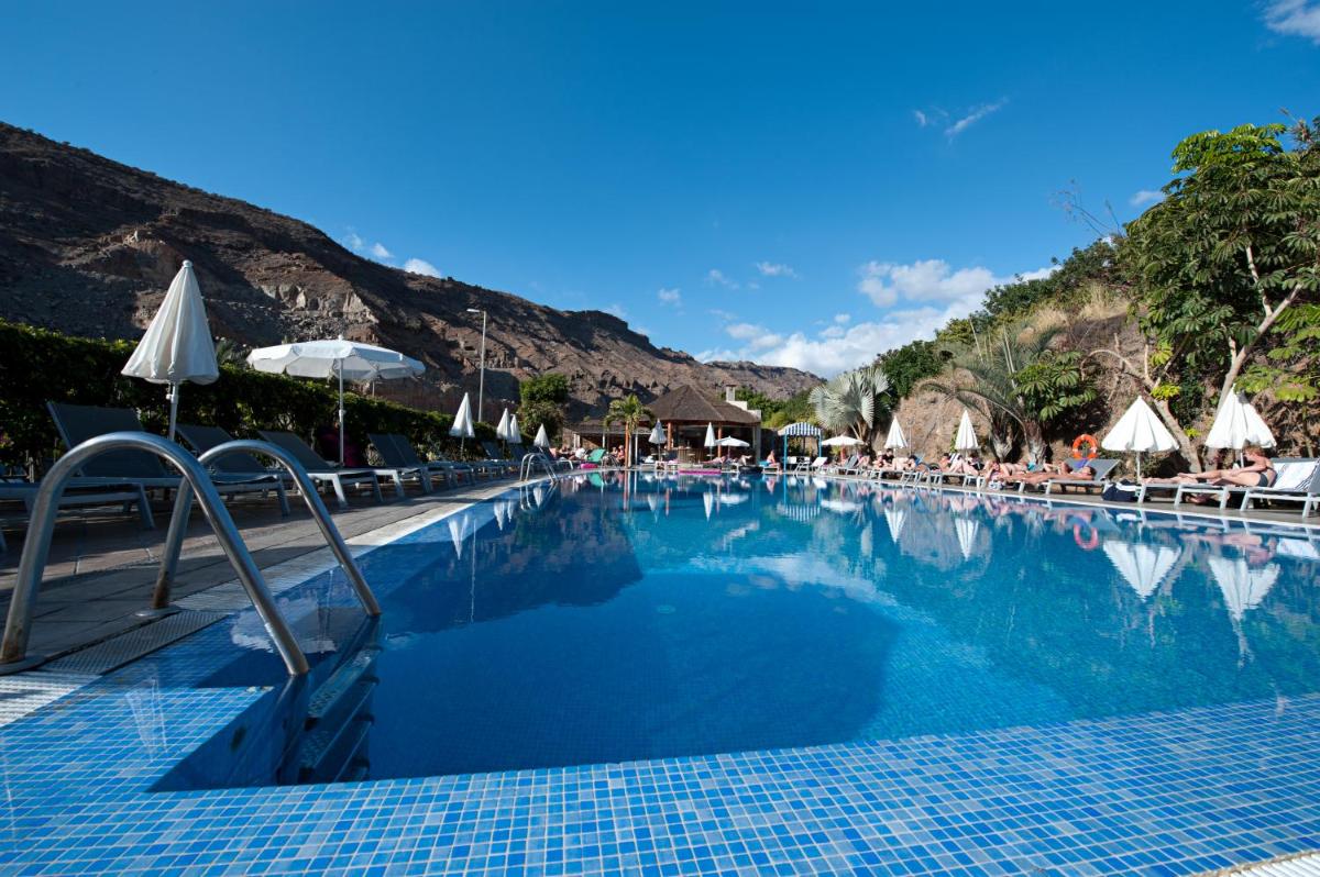 una gran piscina con sillas y sombrillas en Hotel LIVVO Costa Taurito & Aquapark, en Taurito 31 fotos más