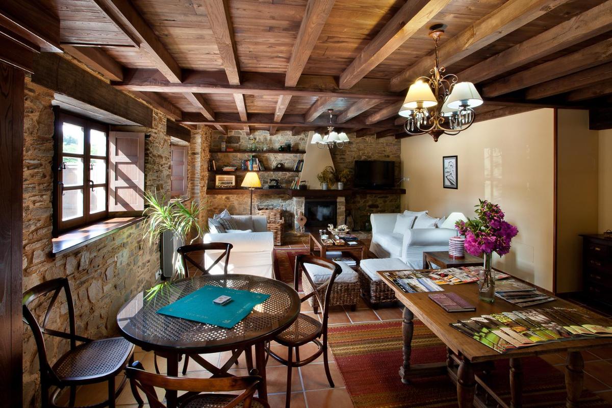 una sala de estar con una mesa y sillas en Hotel Casa Cachón, en Tol