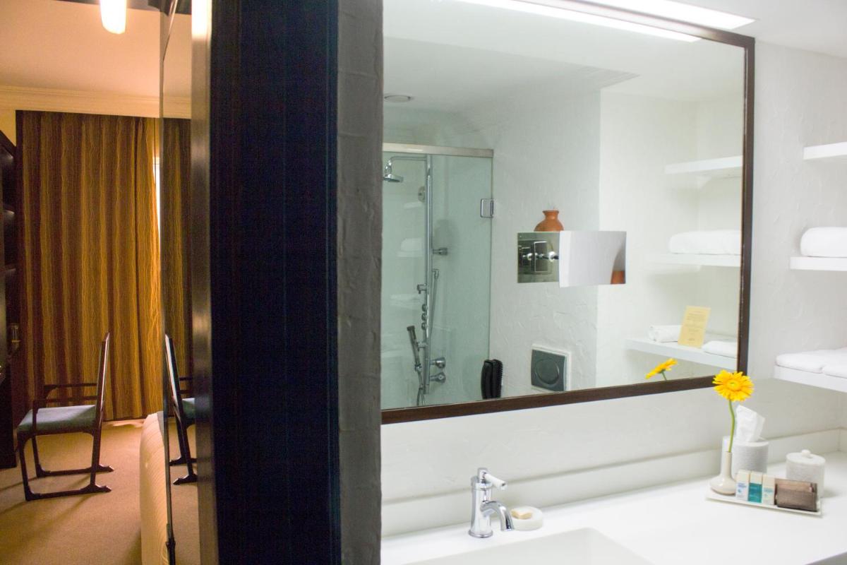 a bathroom with a sink and a large mirror at Sterlings Mac Hotel in Bengaluru