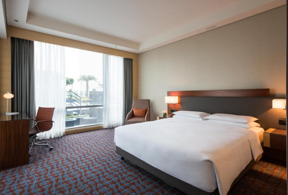 a hotel room with a large bed and a large window at Hyatt Regency Lucknow Gomti Nagar in Lucknow