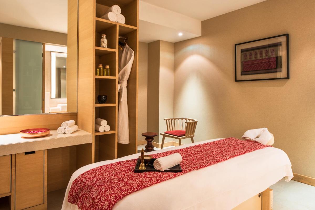 a bedroom with a bed and a table and a chair at Hyatt Regency Lucknow Gomti Nagar in Lucknow