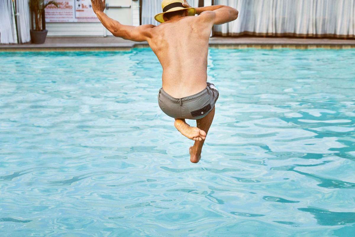 a man is jumping into a swimming pool at Hyatt Regency Lucknow Gomti Nagar in Lucknow