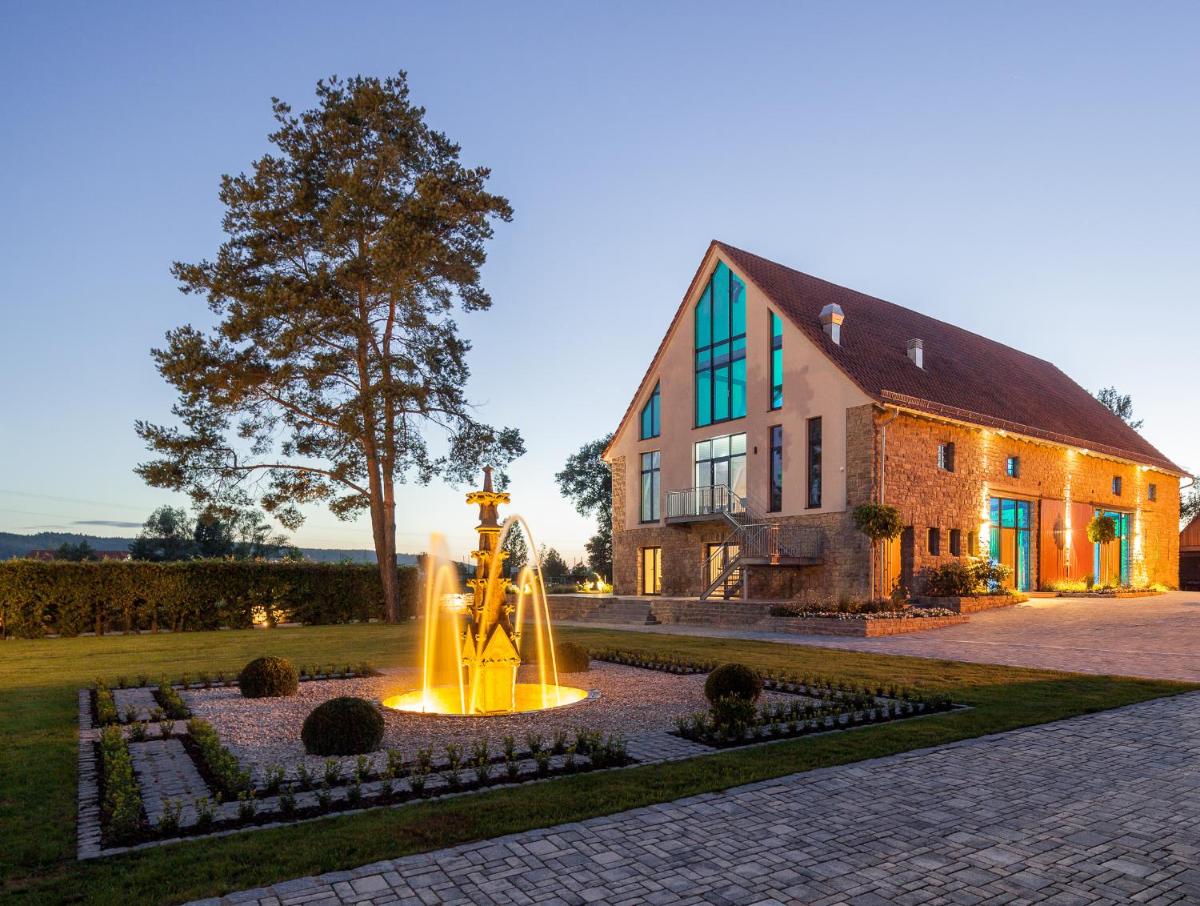 ein Haus mit einem Brunnen vor einem Gebäude in der Unterkunft Hotel Dorfmühle in Lehrberg + 21 Fotos