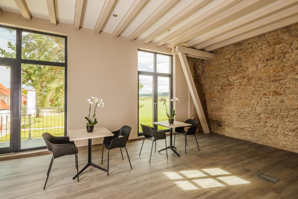 ein Zimmer mit 2 Tischen und Stühlen und einer Ziegelwand in der Unterkunft Hotel Dorfmühle in Lehrberg