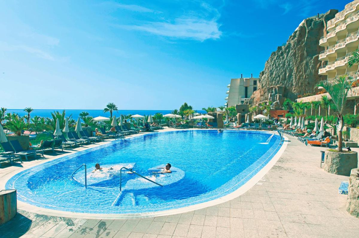 Dos personas en una piscina de un resort. en Hotel LIVVO Valle Taurito & Aquapark, en Taurito 30 fotos más