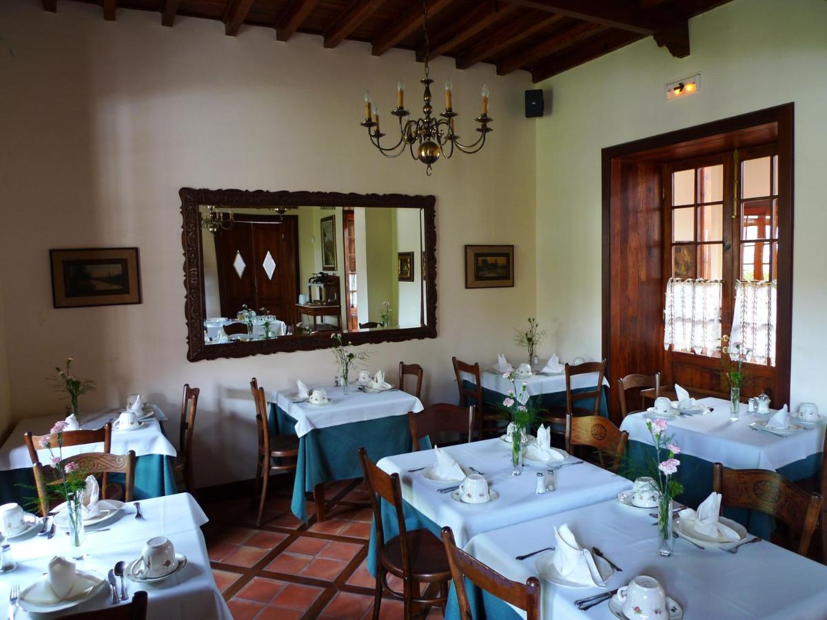 comedor con mesas blancas y espejo en Hotel Rural San Miguel - Only Adults, en San Miguel de Abona