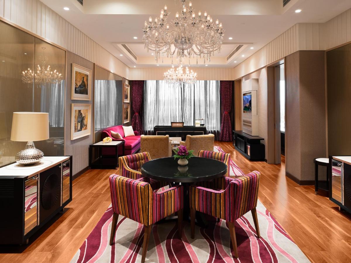 a living room with a chandelier and a table and chairs at Taj Santacruz in Mumbai