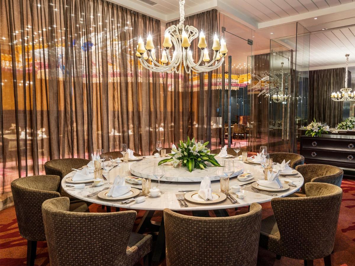 a dining room with a table and chairs at Taj Santacruz in Mumbai