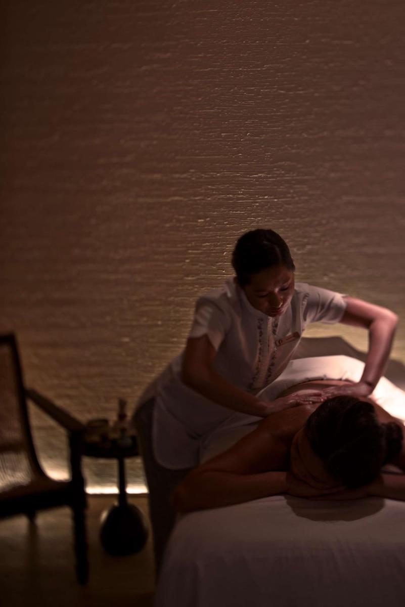 a woman sitting on top of a bed at Park Hyatt Chennai in Chennai