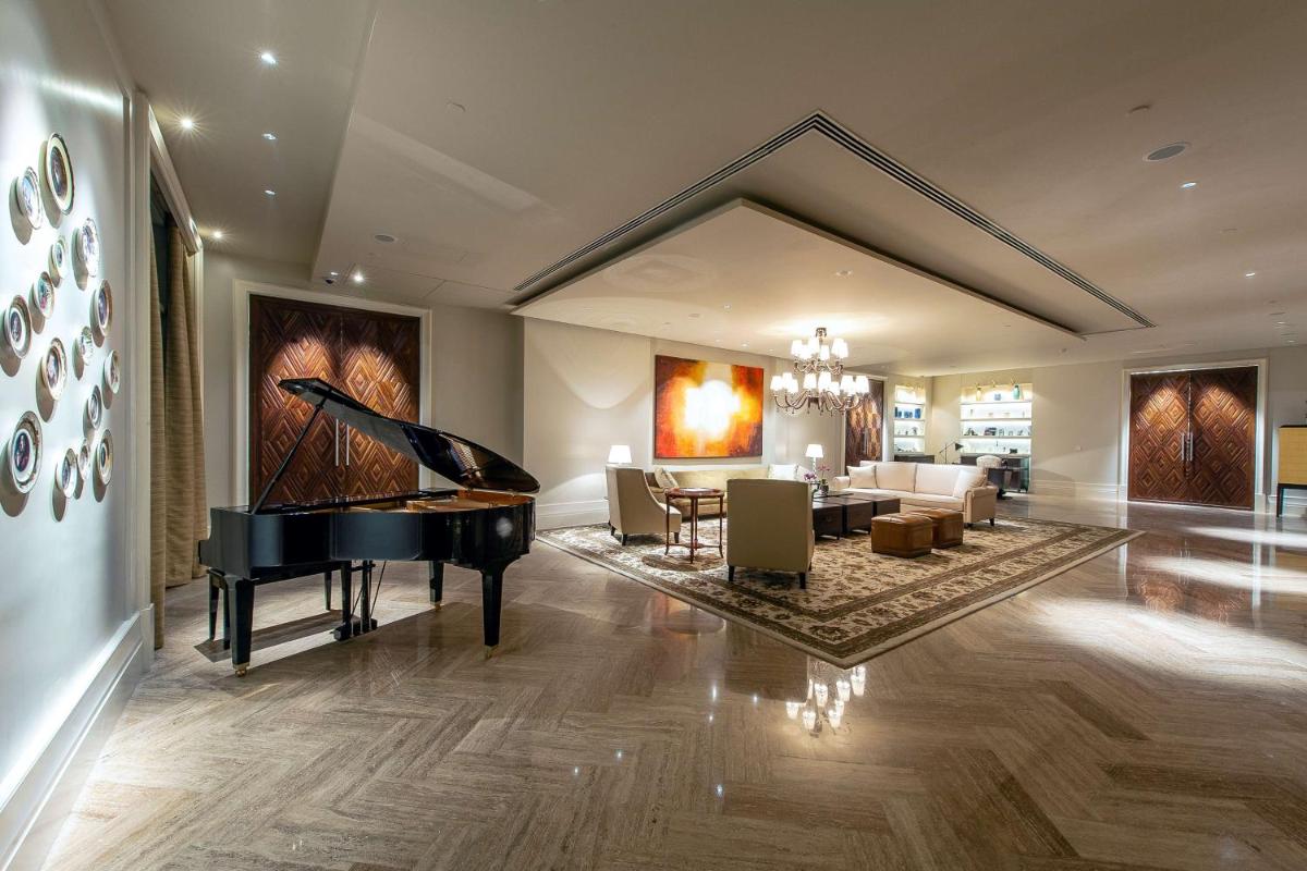 a living room with a piano and a dining room at Park Hyatt Chennai in Chennai
