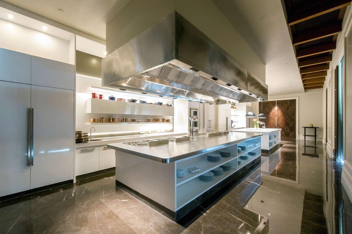 a large kitchen with white cabinets and a large island at Park Hyatt Chennai in Chennai