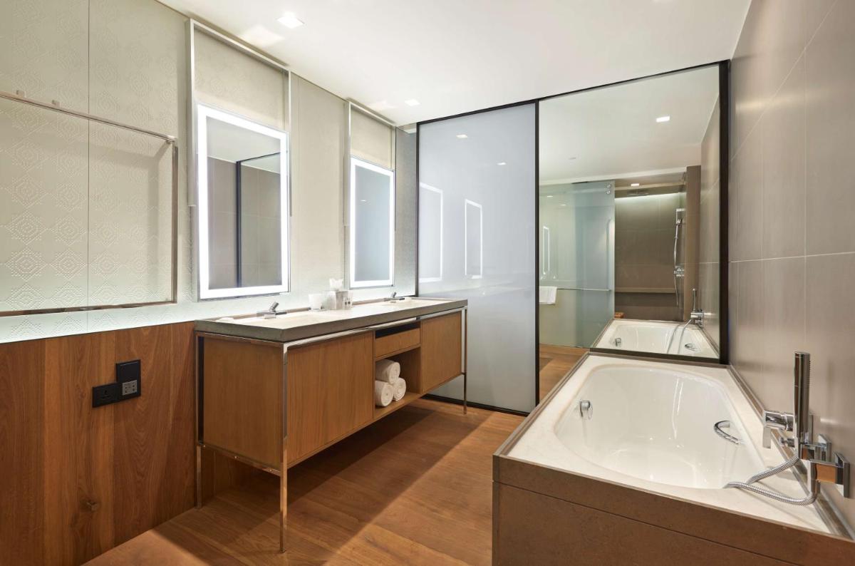 a large bathroom with a tub and a sink at Andaz Delhi, by Hyatt in New Delhi a large bathroom with a tub and a sink at Andaz Delhi, by Hyatt in New Delhi