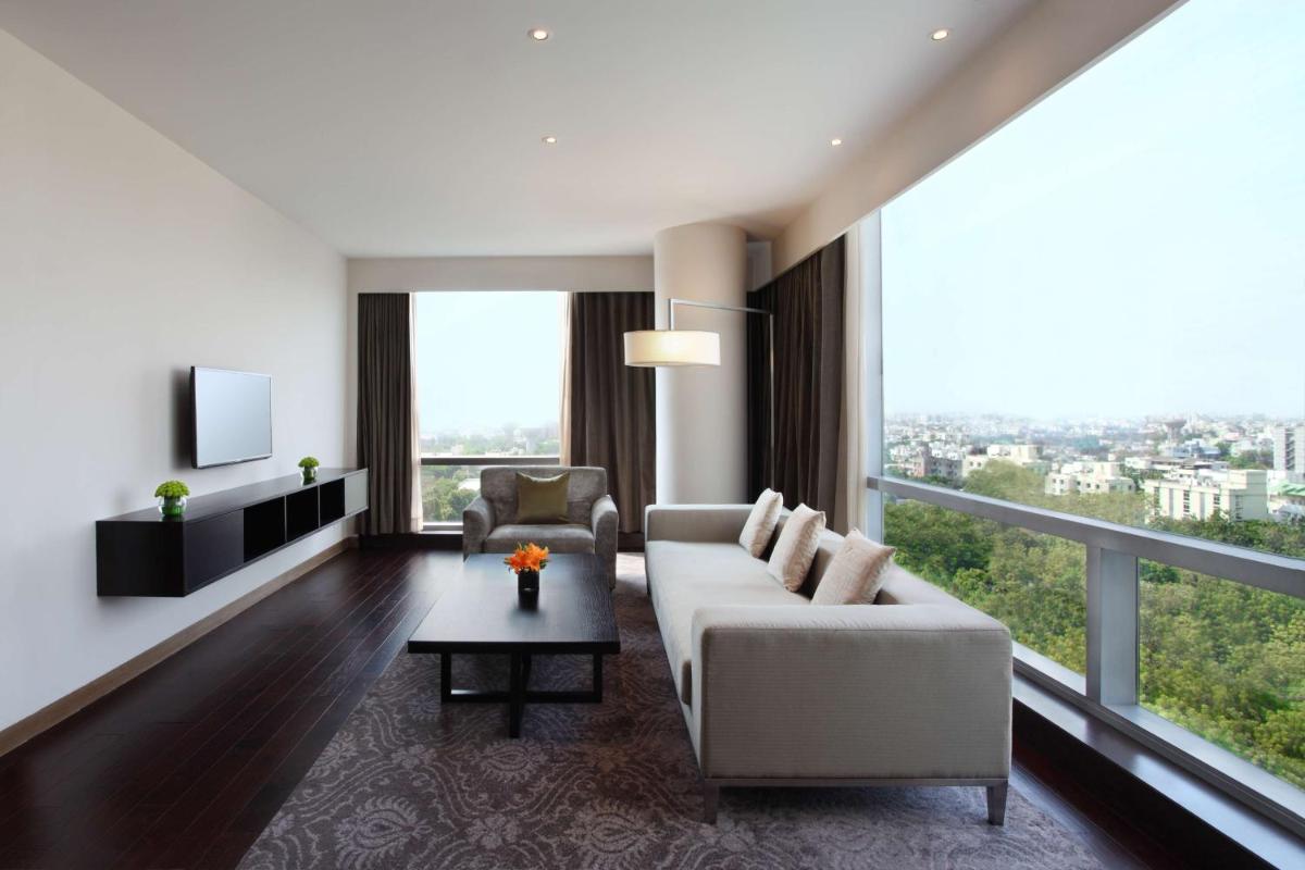 a living room with a white couch and a large window at Hyatt Regency Ahmedabad in Ahmedabad