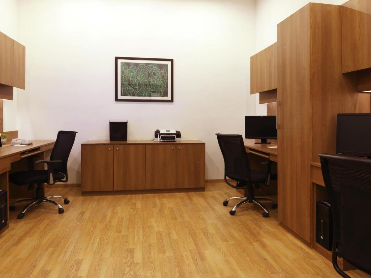 an office with two desks with chairs and a phone at Lemon Tree Premier Hitec City Hyderabad in Hyderabad