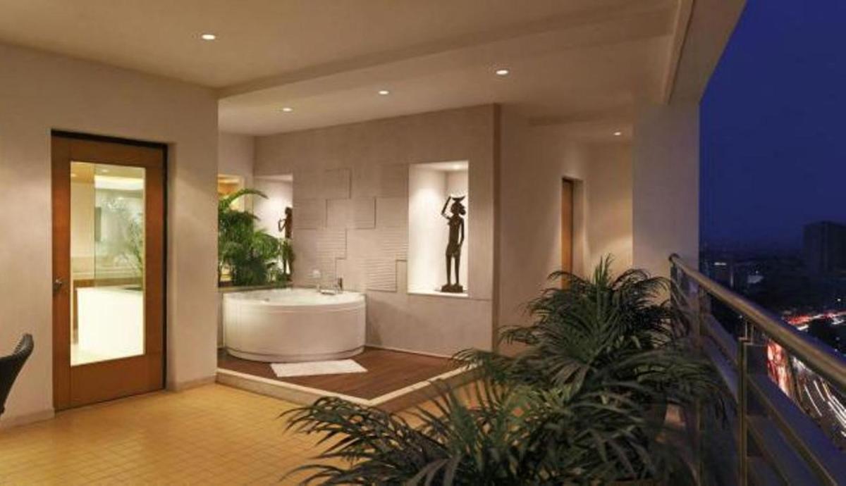 a bathroom with a bath tub in a building at Lemon Tree Premier Hitec City Hyderabad in Hyderabad