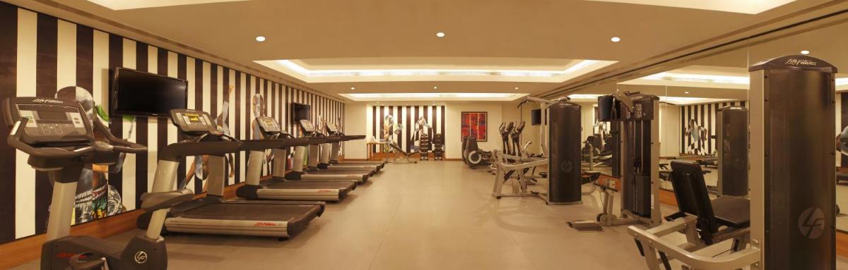 a gym with a row of treadms and machines at Lemon Tree Premier Hitec City Hyderabad in Hyderabad