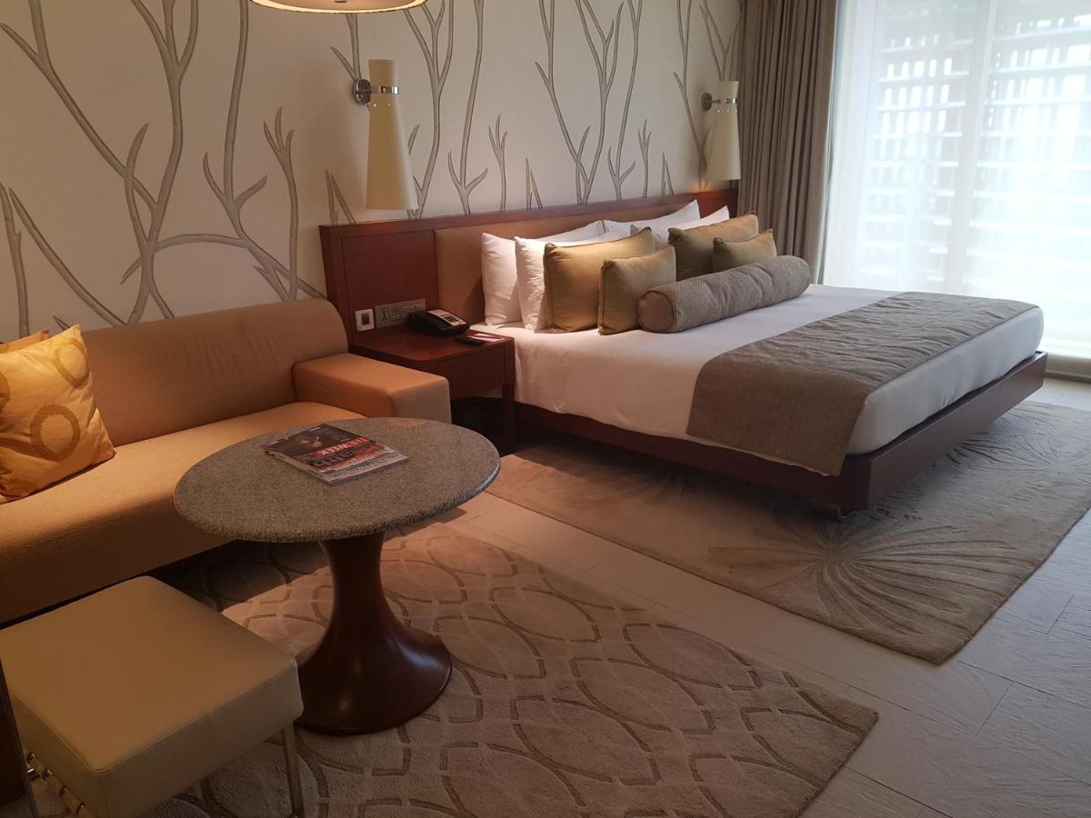 a bedroom with a large bed and a couch at Taj Yeshwantpur Bengaluru in Bengaluru a bedroom with a large bed and a couch at Taj Yeshwantpur Bengaluru in Bengaluru