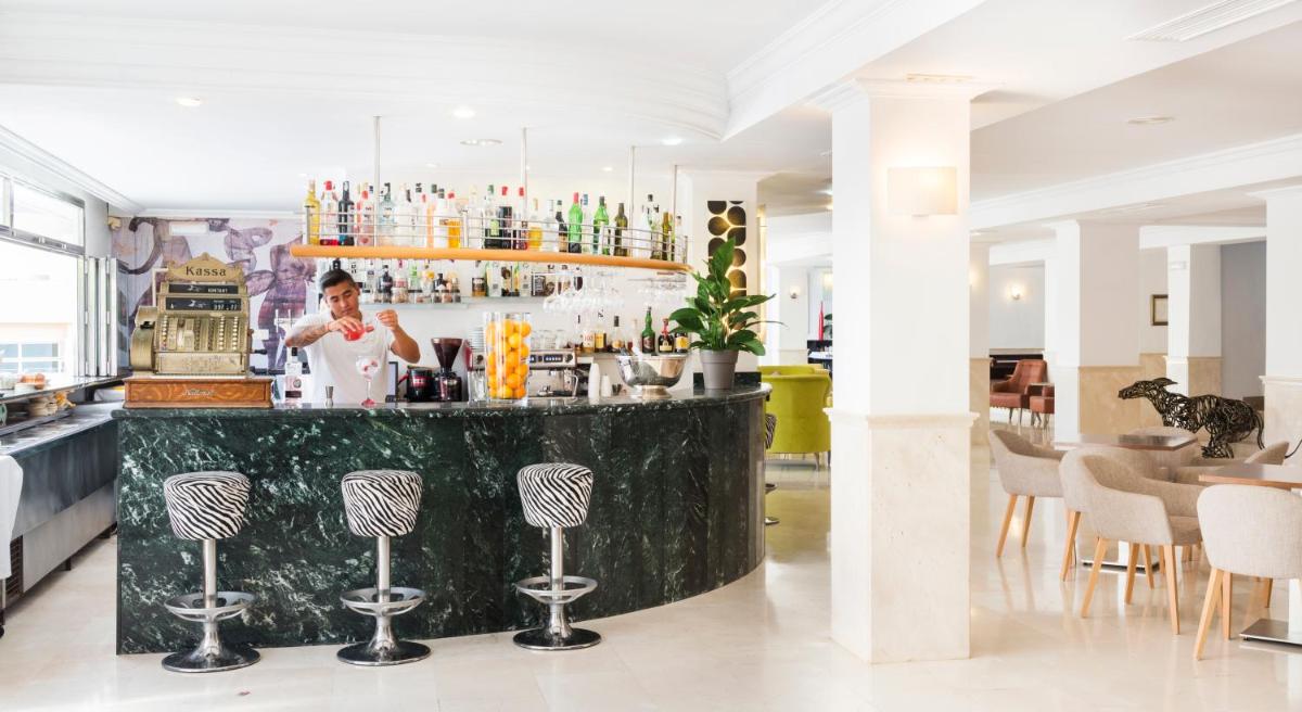 un camarero detrás de un bar en un restaurante en Hotel Morito, en Cala Millor