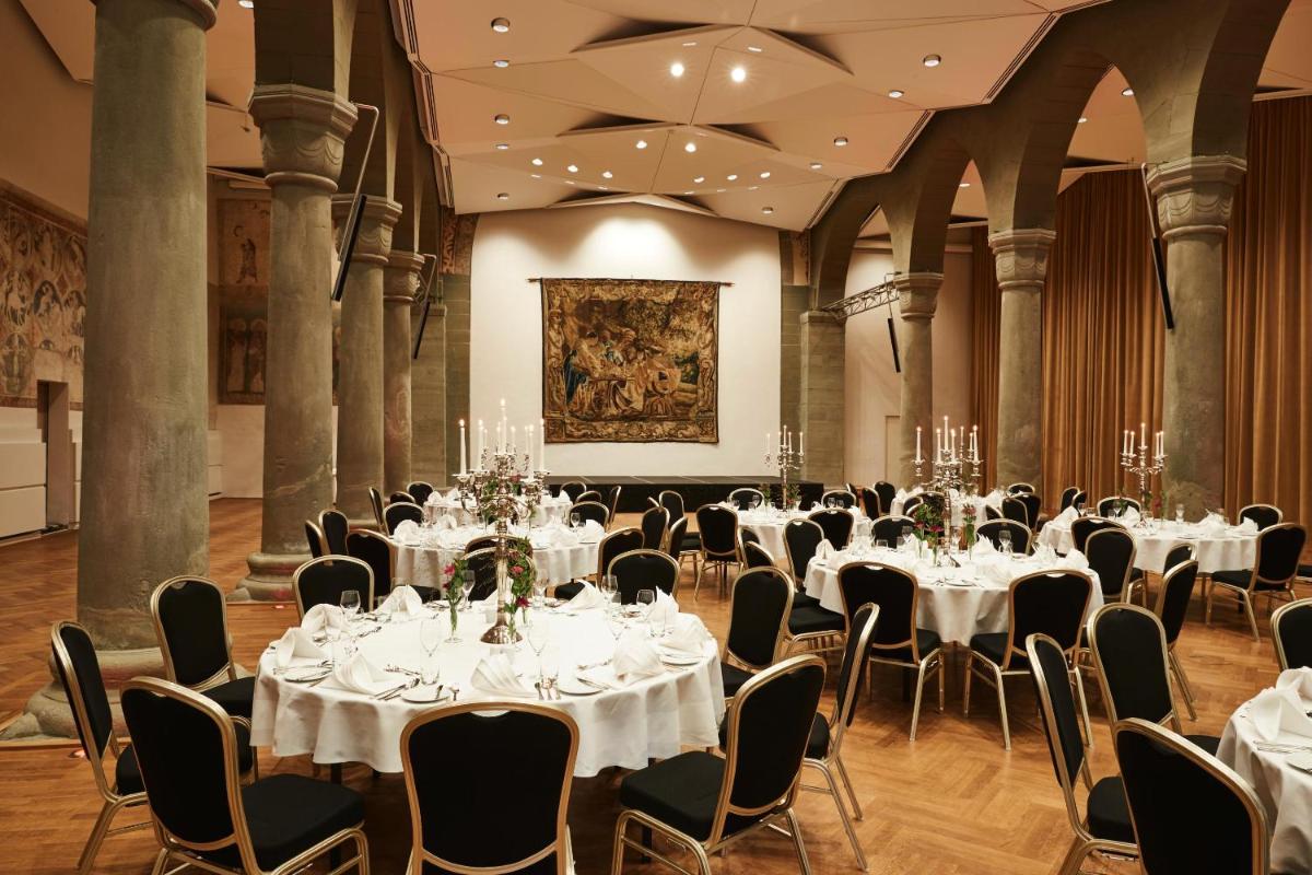 ein Bankettsaal mit weißen Tischen und Stühlen in der Unterkunft Steigenberger Inselhotel in Konstanz