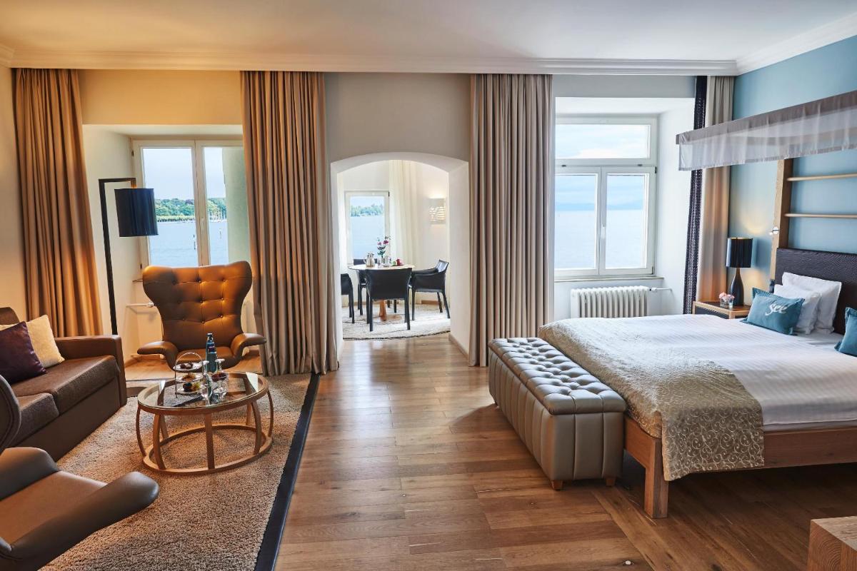 ein Schlafzimmer mit einem Bett, einer Couch und einem Tisch in der Unterkunft Steigenberger Inselhotel in Konstanz + 37 Fotos