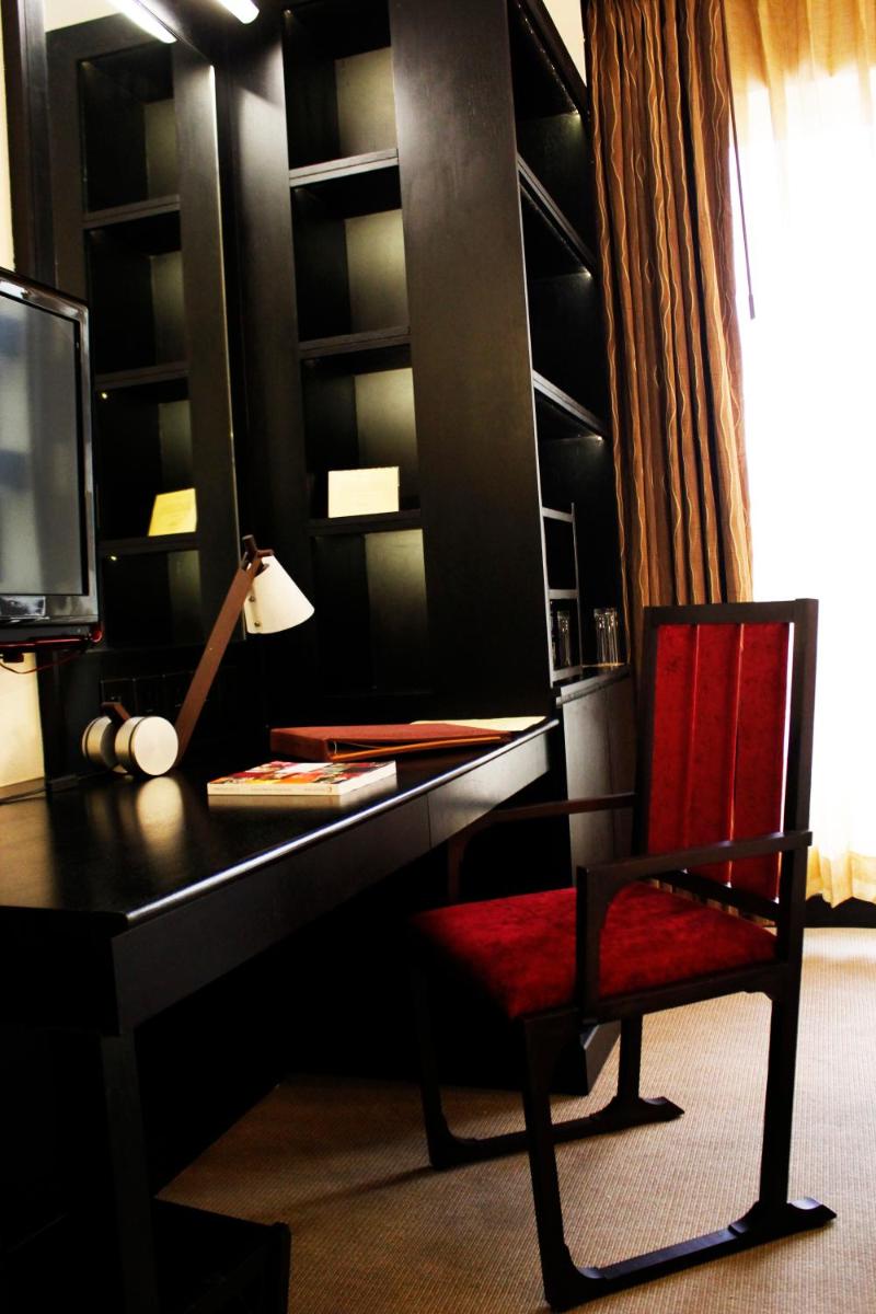 a red chair sitting at a desk with a computer at Sterlings Mac Hotel in Bengaluru