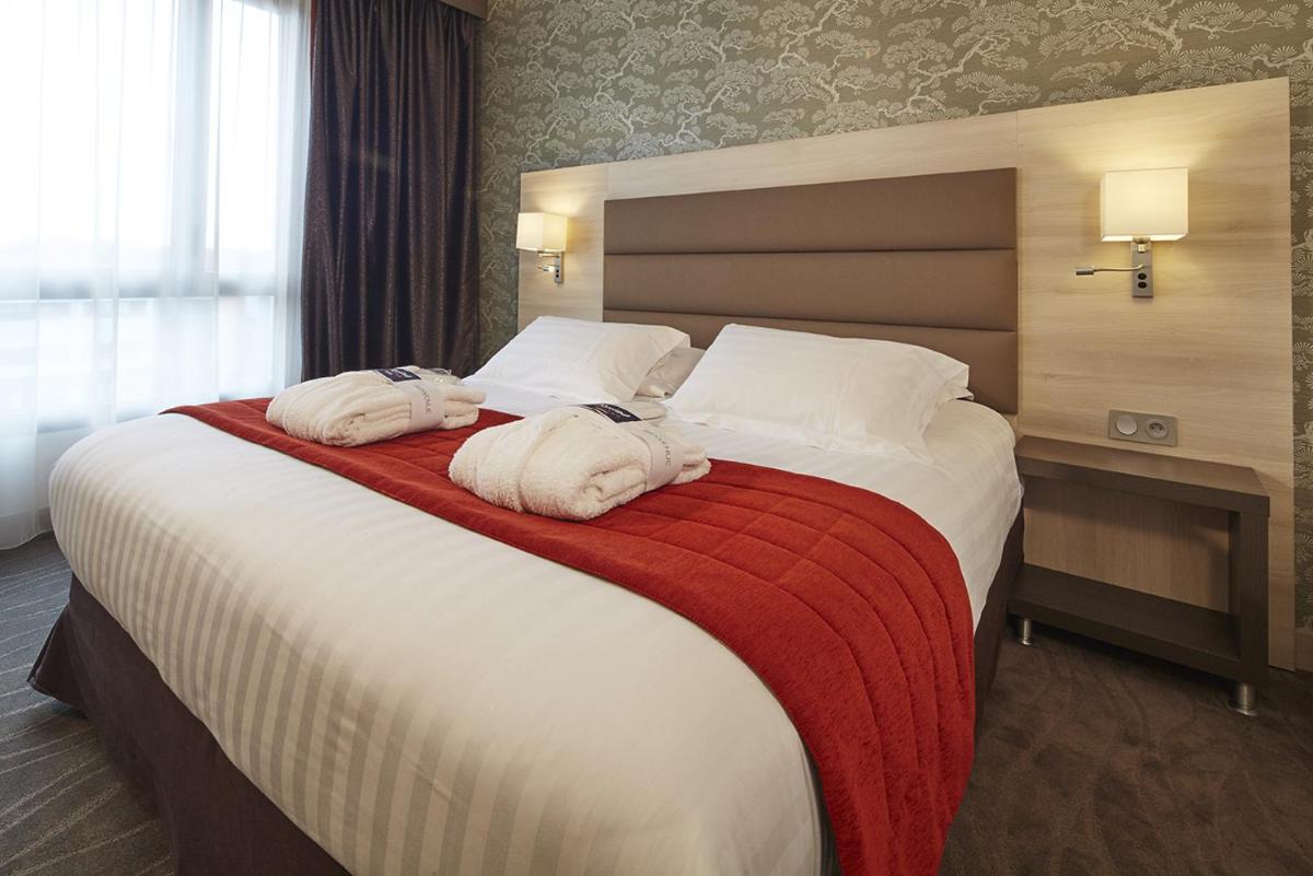 Un ou plusieurs lits dans un hébergement de l'établissement Kyriad Prestige Lyon Est - Saint Priest Eurexpo Hotel and SPA