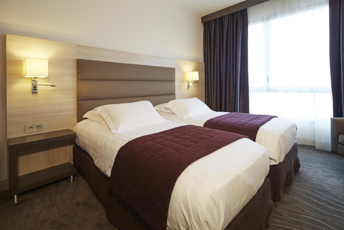 Un ou plusieurs lits dans un hébergement de l'établissement Kyriad Prestige Lyon Est - Saint Priest Eurexpo Hotel and SPA