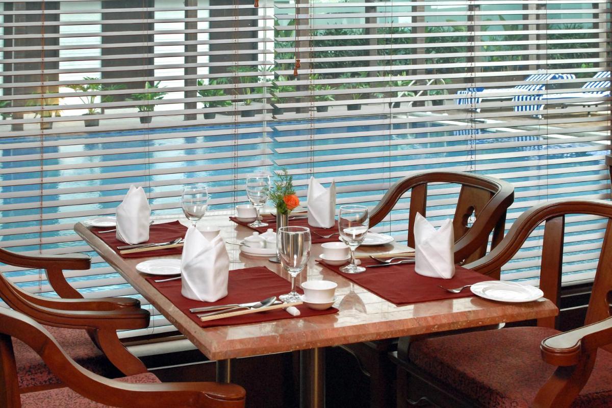 a wooden table with napkins and glasses on it at Fortune JP Palace, Mysore - Member ITC Hotels' Group in Mysore