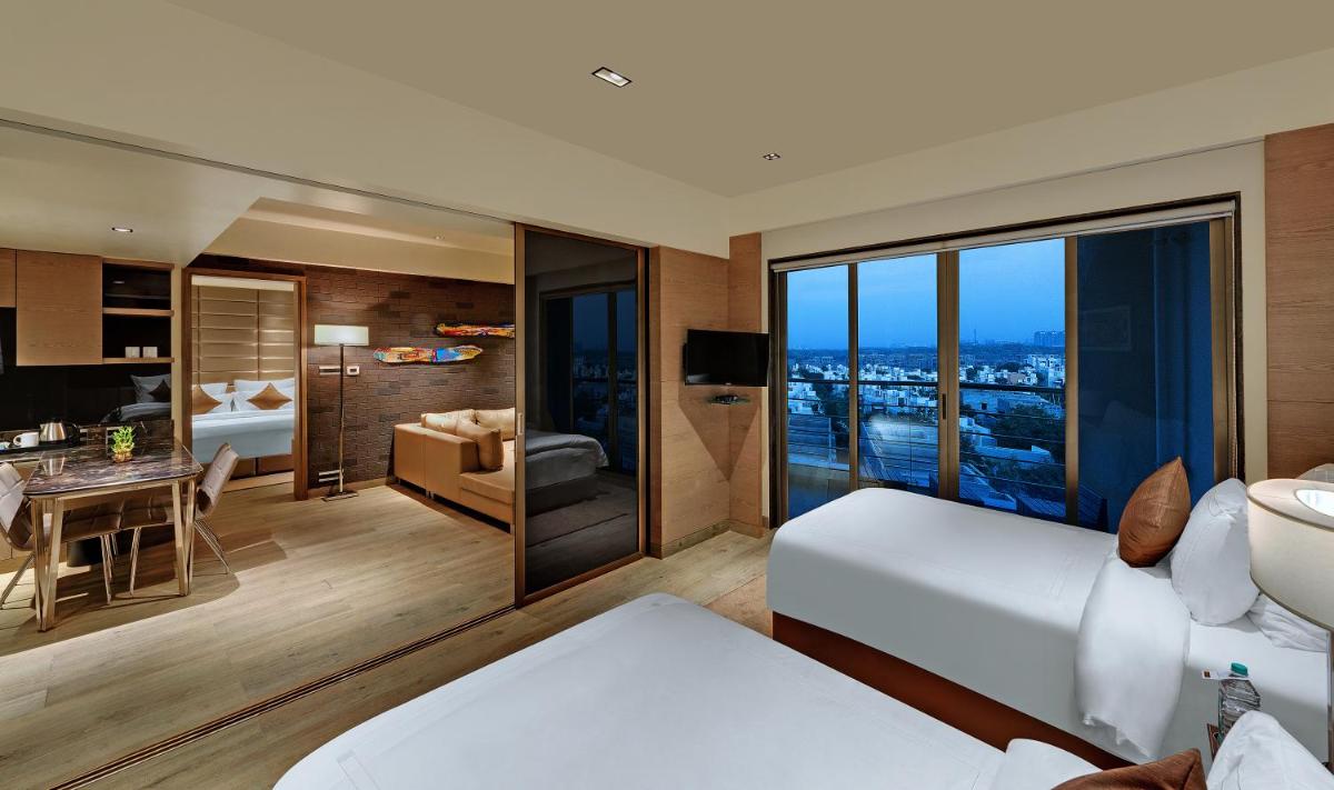 a hotel room with a view of a bedroom at Wyndham Ahmedabad Shela in Ahmedabad