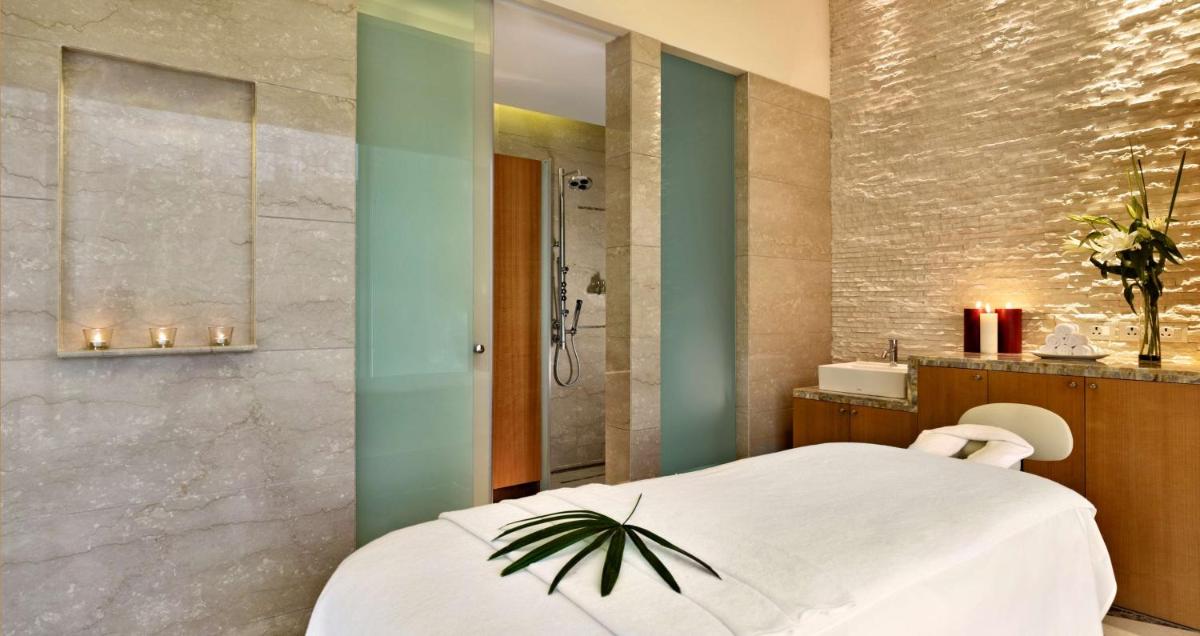 a bathroom with a white bed and a shower at Hyatt Regency Pune Hotel & Residences in Pune