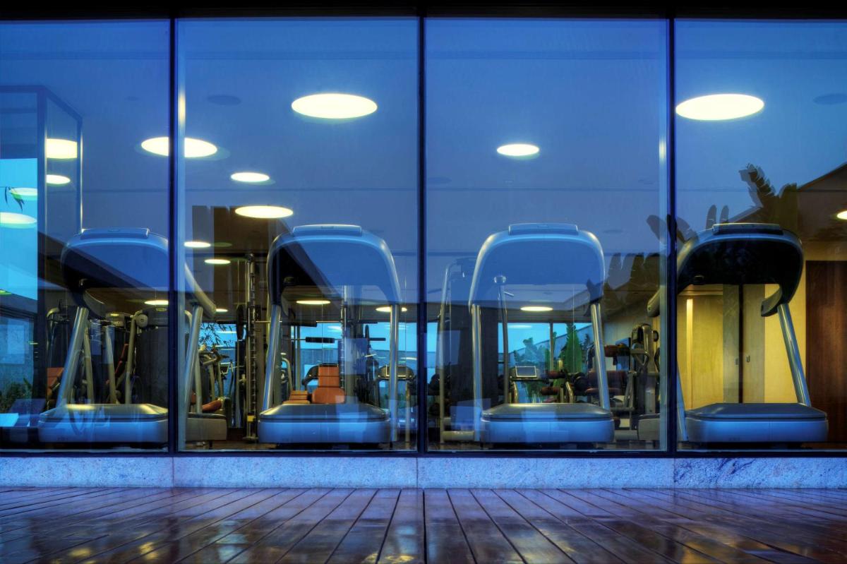 a reflection of a glass building with escalators in it at Park Hyatt Hotel and Residences, Hyderabad in Hyderabad