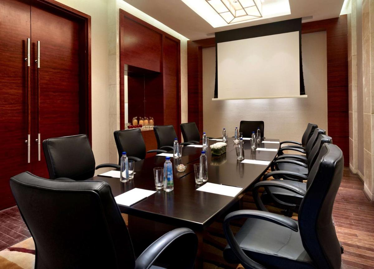 a conference room with a long table and black chairs at Hyatt Regency Pune Hotel & Residences in Pune