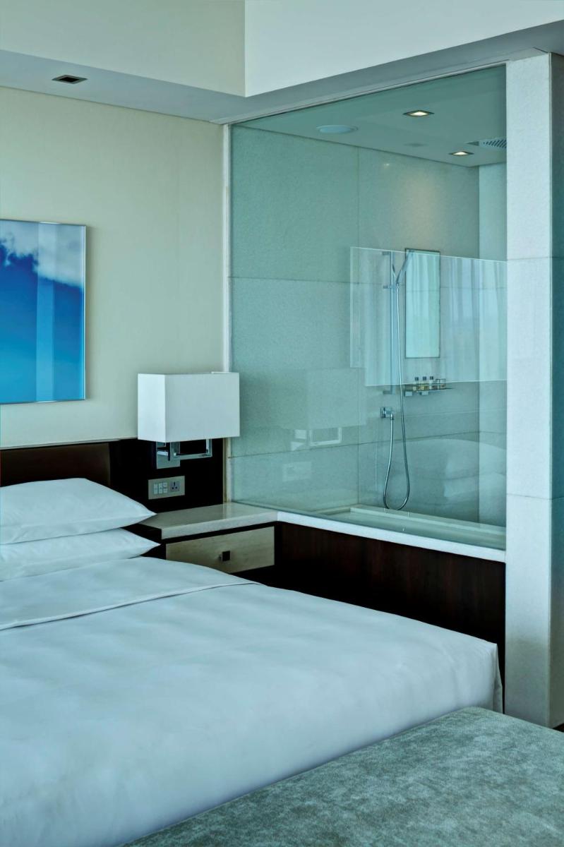 a bedroom with four beds and a bath tub at Park Hyatt Hotel and Residences, Hyderabad in Hyderabad