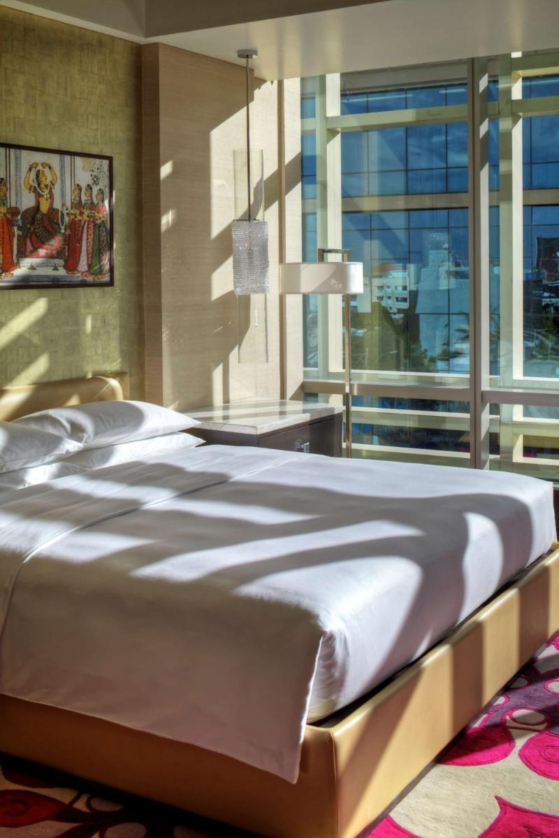 a large bed in a bedroom with a large window at Park Hyatt Hotel and Residences, Hyderabad in Hyderabad
